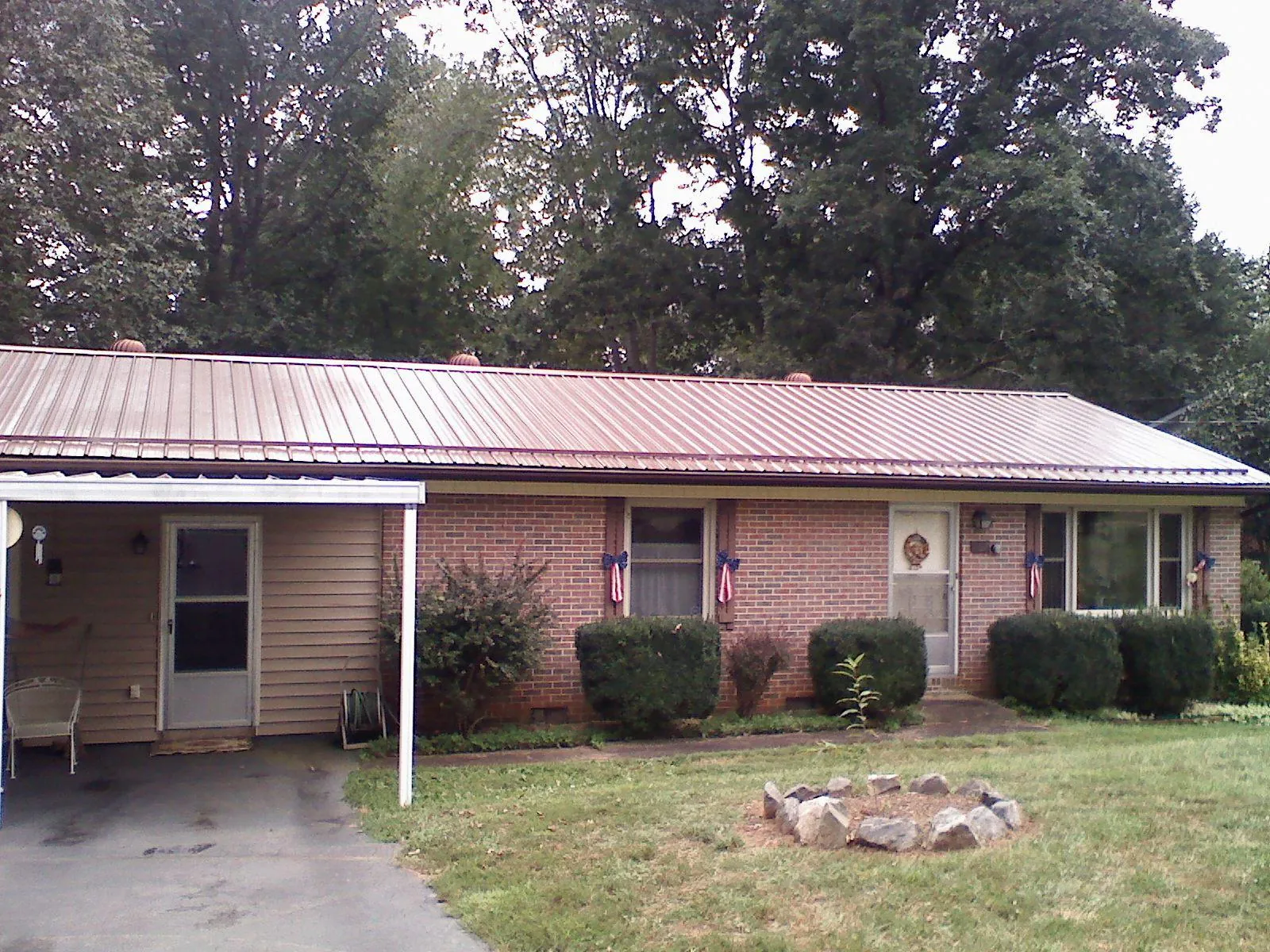 Bronze metal roof and carport on a brick ranch home — Roof Repair work by our crew in Buxton